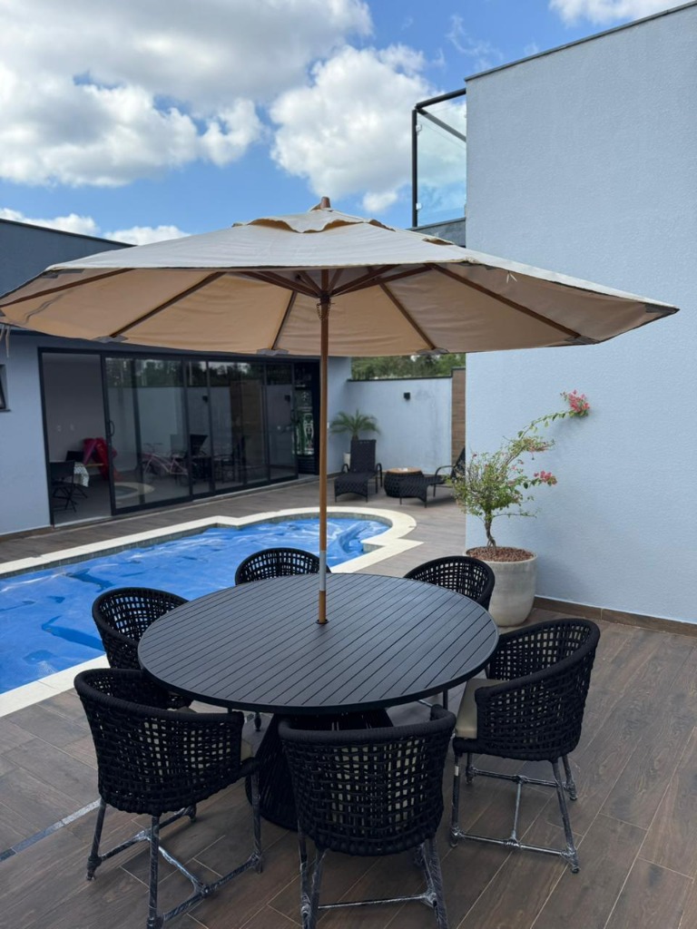 Área de deck com piscina — ombrelone central